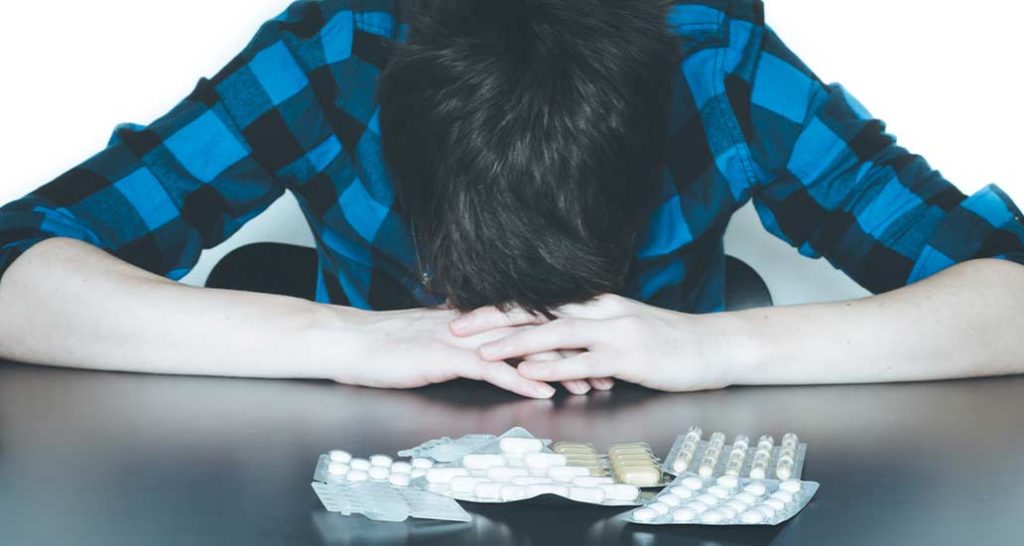 man with his head down on a table suffering from benzodiazepine addiction