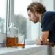 man looking out of his window with alcohol in the foreground
