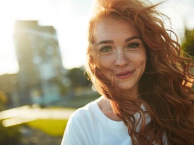 happy woman with red hair outside