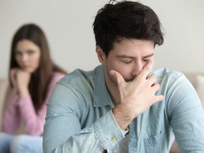 thoughtful man with lady in background