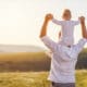 man carrying child on shoulders with nice view outdoors