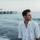 man with ocean and pier in background