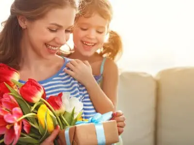mother and daughter with present and tulips
