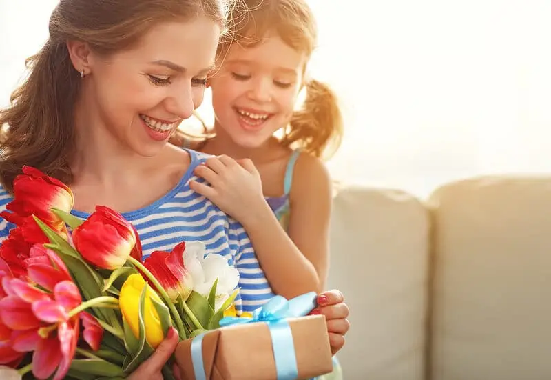 mother and daughter with present and tulips