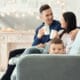 young couple with coffee mugs and child peeking over