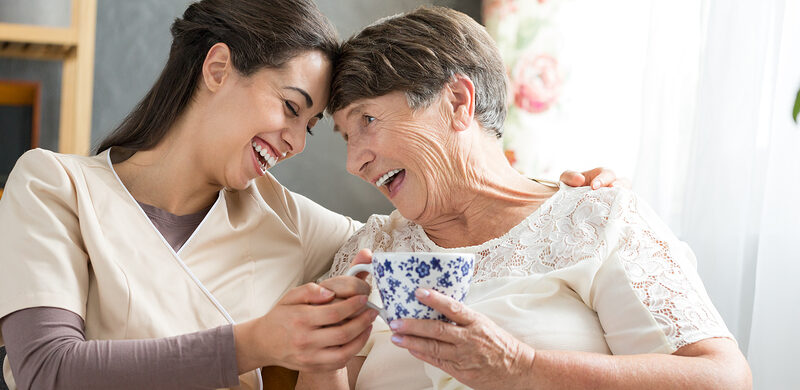 care giver with senior lady offering coffee