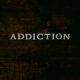 the word addiction on a dark wood background