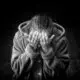 black and white photo of a woman with her head buried in her hands displaying grief
