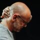 a man in pain grabbing his neck for relief.