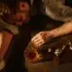 photograph of a man passed out from alcohol with an unfinished whiskey nearby.