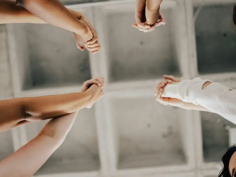 a group of people joining hands in unity