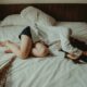 a woman laying in bed fully clothed going through recovery