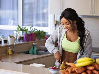 a woman preparing a healthy meal with fruit and vegetables.