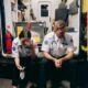 two first responders sitting in the back of their rig hunched over