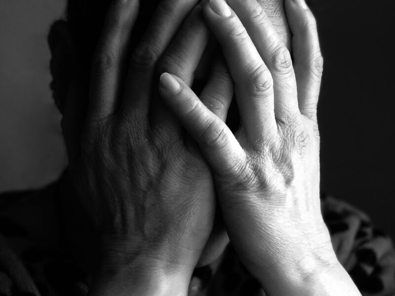a man with his face between his hands displaying shame