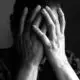 a man with his face between his hands displaying shame