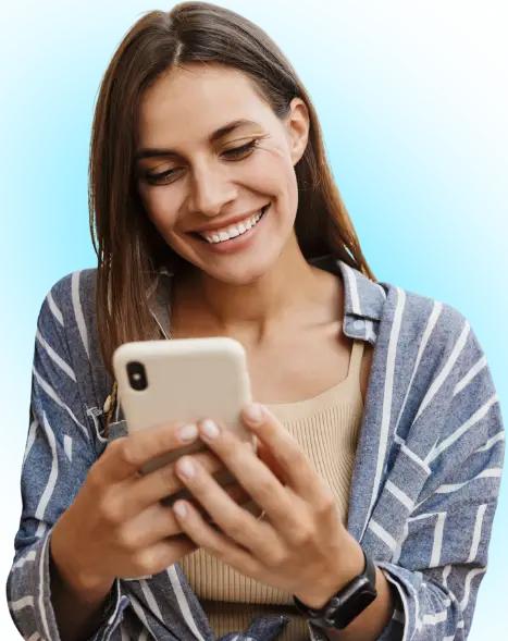 Woman smiling while using smartphone against blue background