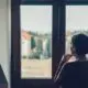 Person experiencing post-acute alcohol withdrawal symptoms, sitting with head in hands during recovery.