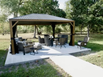 Outdoor gazebo with wicker seating on a patio surrounded by trees at a Biloxi rehab facility.