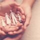 Cupped hands holding a paper cutout of a family, symbolizing family support in addiction recovery.